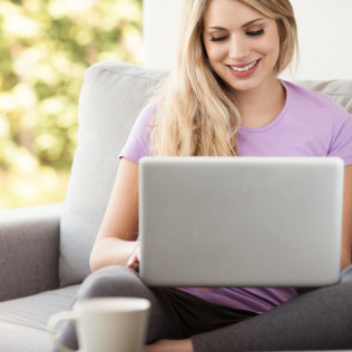 smiling woman sitting with a computer